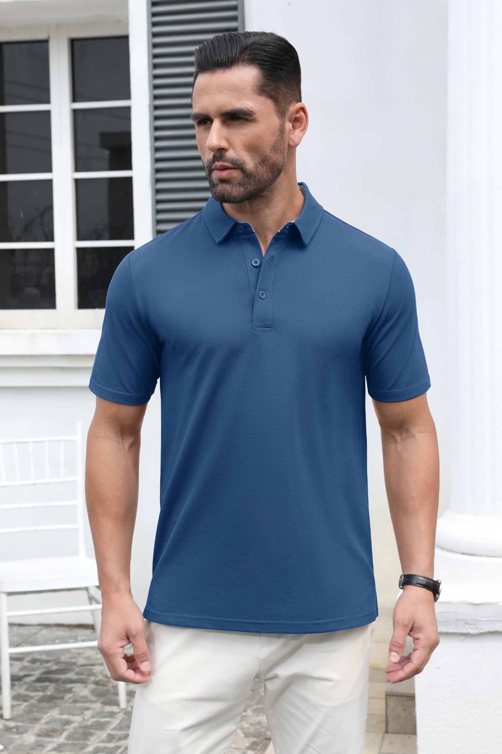 Man wearing a blue polo shirt standing outdoors.